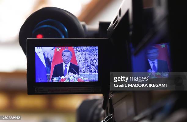 Reporter records video footage of Chinese State Councilor and Foreign Minister Wang Yi speaking during his press conference with Russias Foreign...