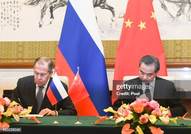 Russias Foreign Minister Sergei Lavrov and Chinese State Councilor and Foreign Minister Wang Yi sign after their meeting at the Diaoyutai State Guest...