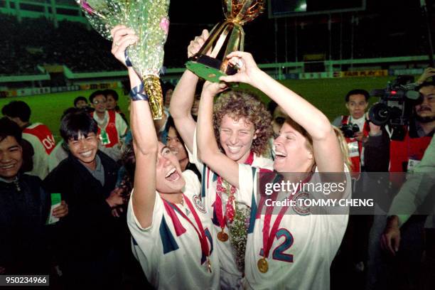 Michelle Akers-Stahl who scored two goals for the US to win the first FIFA World Championship for Women's Football on November 30 holds the trophy...