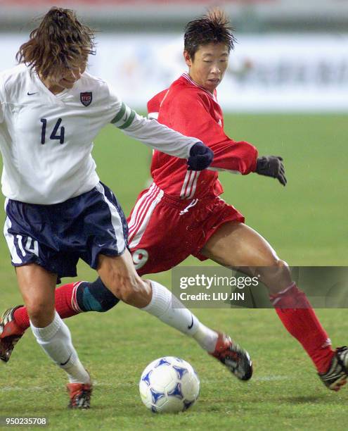 Chinese player Bai Jie chases the ball with Joy Faweett of USA during Four Nations Women Soccer Championshipin in Wuhan, China's 26 January 2003....