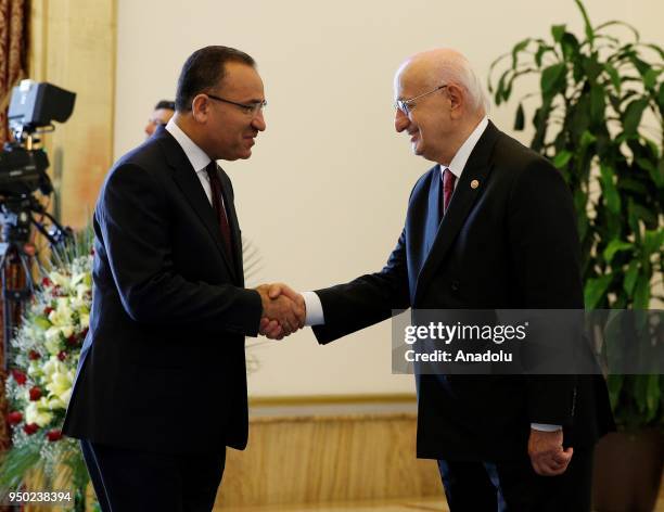 Speaker of the Grand National Assembly of Turkey Ismail Kahraman shakes hands with Turkish Deputy Prime Minister Bekir Bozdag as he accepts the...