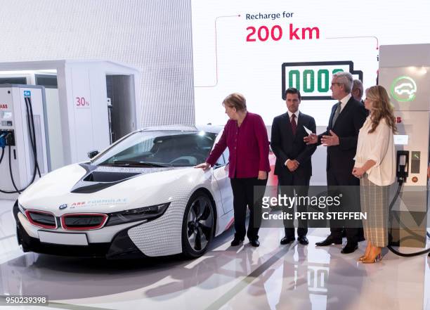 German Chancellor Angela Merkel , Mexican President Enrique Pena Nieto and his wife Angelica Rivera stand next to a BMW i8 on April 23, 2018 as they...