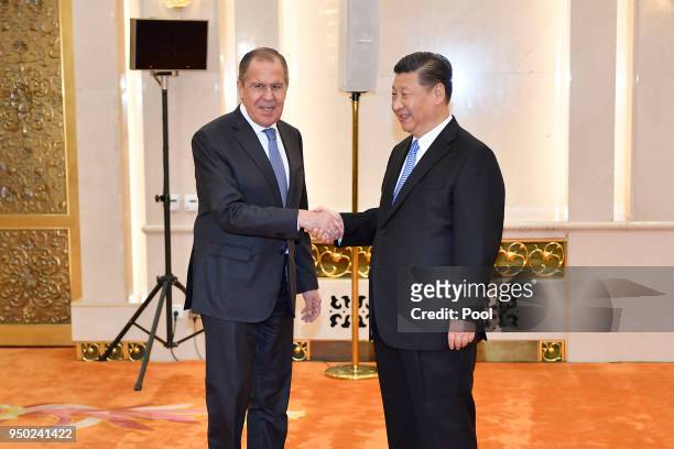 Russian Foreign Minister Sergei Lavrov shakes hands with Chinese President Xi jinping before a meeting at the Great Hall of the People in Beijing,...