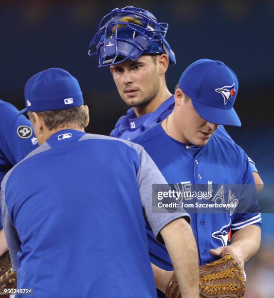 Aaron Loup of the Toronto Blue Jays exits the game as he is relieved by manager John Gibbons as Luke Maile looks on in the eighth inning during MLB...