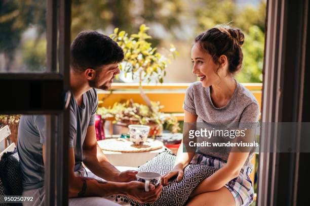 romántico joven pareja relajante en la mañana en el balcón del apartamento - té terraza fotografías e imágenes de stock