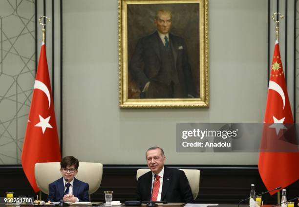 President of Turkey Recep Tayyip Erdogan gestures with Fatih Mintas , a 6th grade student from Cenk Yakin Secondary School sitting on the President's...