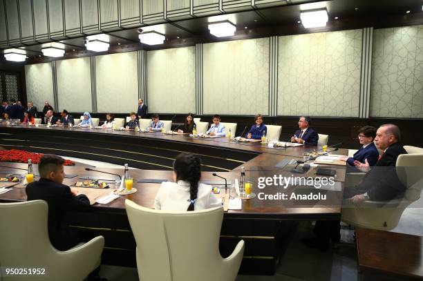 President of Turkey Recep Tayyip Erdogan speaks as Fatih Mintas , a 6th grade student from Cenk Yakin Secondary School sitting on the President's...