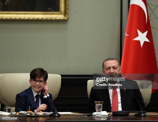 President of Turkey Recep Tayyip Erdogan gestures with Fatih Mintas , a 6th grade student from Cenk Yakin Secondary School sitting on the President's...