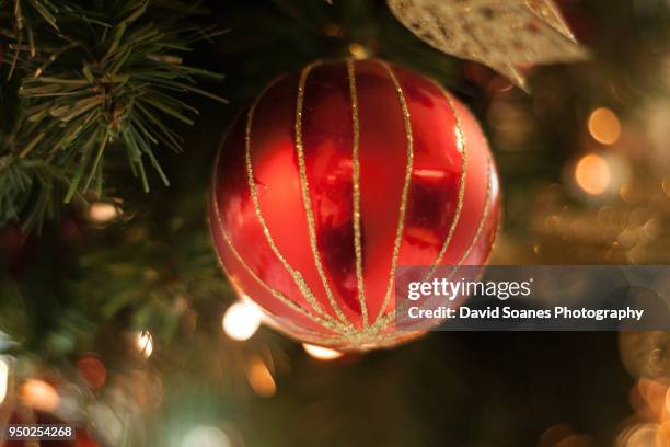 a bauble on a christmas tree - david soanes stock pictures, royalty-free photos & images