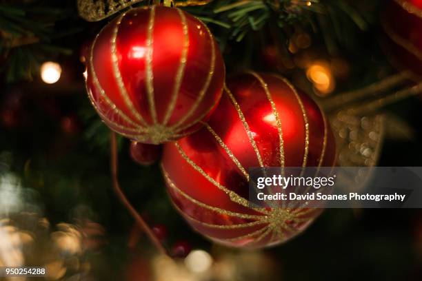 a bauble on a christmas tree - david soanes stock pictures, royalty-free photos & images