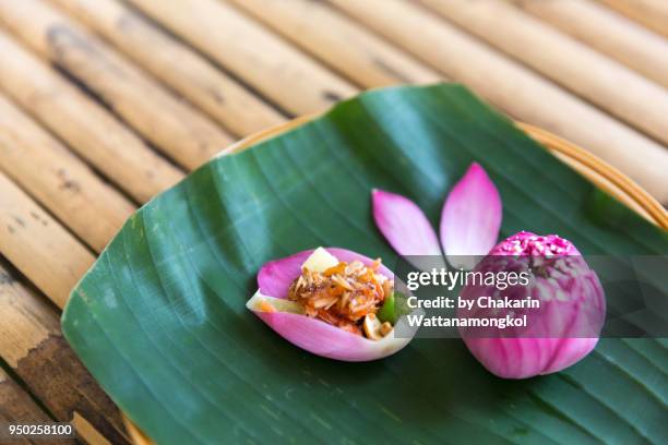 miang kham : pouches of goodness - colorful lotus water lily petals fill with various ingredients - bananenblatt stock-fotos und bilder