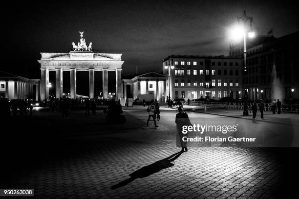 Image has been converted to black and white.) BERLIN, GERMANY The silhouette of a walking woman is pictured in front of the Brandenburg Gate on April...