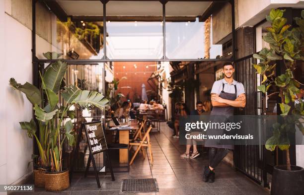 young male business owner standing outside hipster urban café - minute stock pictures, royalty-free photos & images