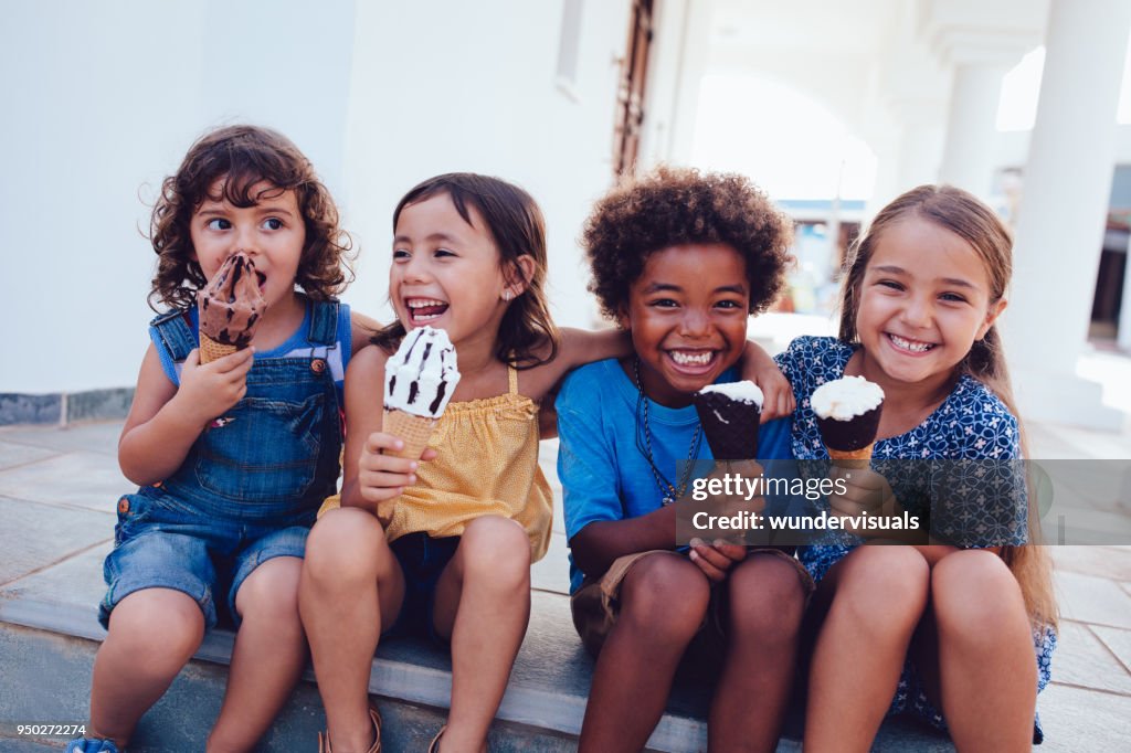 Gruppe von fröhlichen multi-ethnischen Kinder essen Eis im Sommer