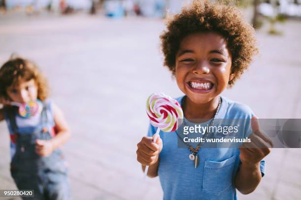 multi-ethnischen kinder mit bunten lutscher im freien im sommerurlaub - eating candy stock-fotos und bilder