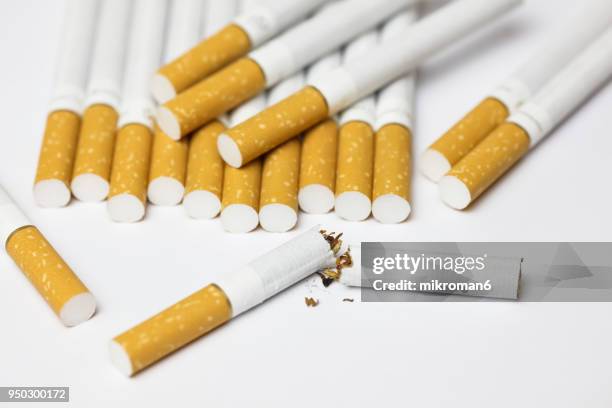 breaking the habit. cigarettes on white background - filtre de cigarette photos et images de collection