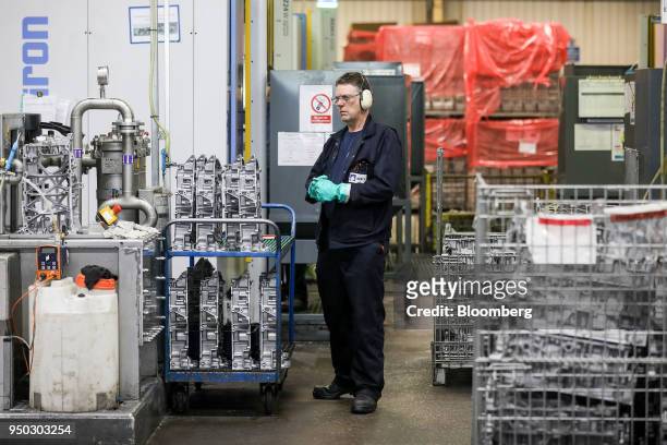 An employee stands near a cutting machine for panther ladder frames at Liberty Aluminium Technologies in Coventry, U.K., on Monday, April 23, 2018....
