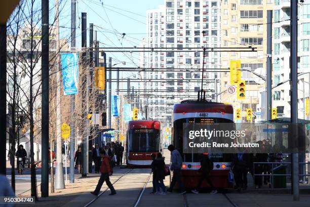 Passengers cut around back of a TTC streetcar as another approaches at York and Queens Quay. The streetcar tracks are a no-go zone for autos.Rene...