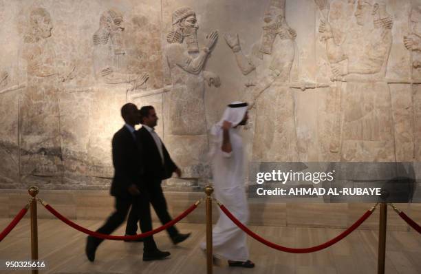 Emirati men walk at the Iraqi National Museum in Baghdad on April 23, 2018. - The United Arab Emirates and Iraq signed an agreement to develop the...