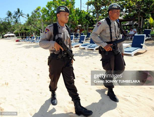 In this photograph taken on November 13, 2011 armed Indonesian marine policemen patrol the beach area in Nusa Dua near the venue of the 19th...