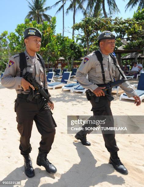 In this photograph taken on November 13, 2011 armed Indonesian marine policemen patrol the beach area in Nusa Dua near the venue of the 19th...