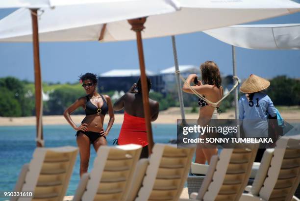 In this photograph taken on November 13, 2011 a group of tourists enjoy the sun in the beach near the venue of the 19th Association of Southeast...
