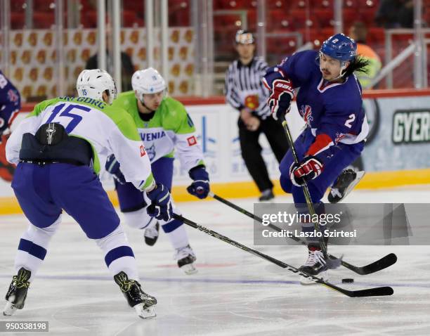 Dallas Ehrhardt of Great Britain shoots on goal next to Blaz Gregorc of Slovenia during the 2018 IIHF Ice Hockey World Championship Division I Group...