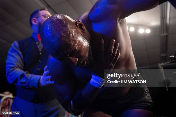 Professional wrestler Derrick Green Jr. , better known by his ring name Napalm Bomb, holds his neck as he is helped out of the ring after losing by...