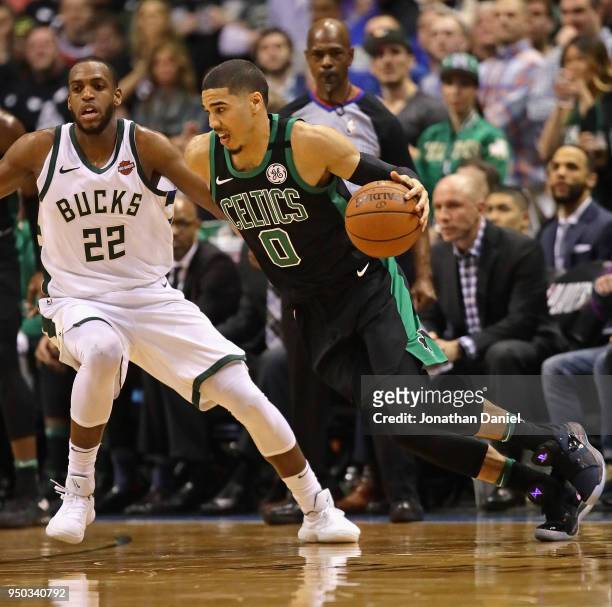 Jayson Tatum of the Boston Celtics drives around Khris Middleton of the Milwaukee Bucks during Game Four of Round One of the 2018 NBA Playoffs at the...