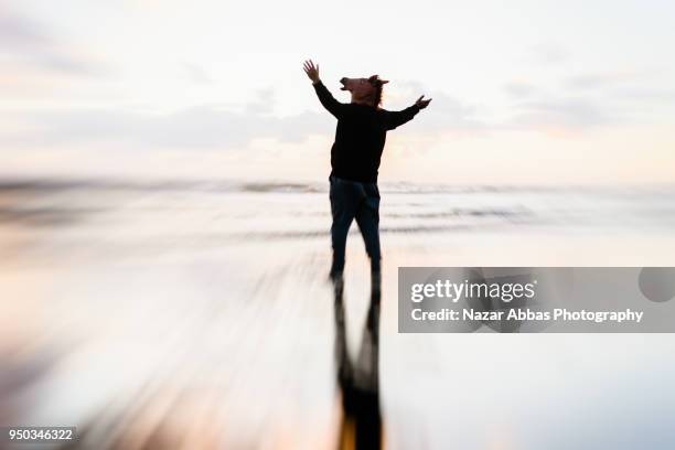 horse mask man with open arms at beach. - nazar abbas foto e immagini stock