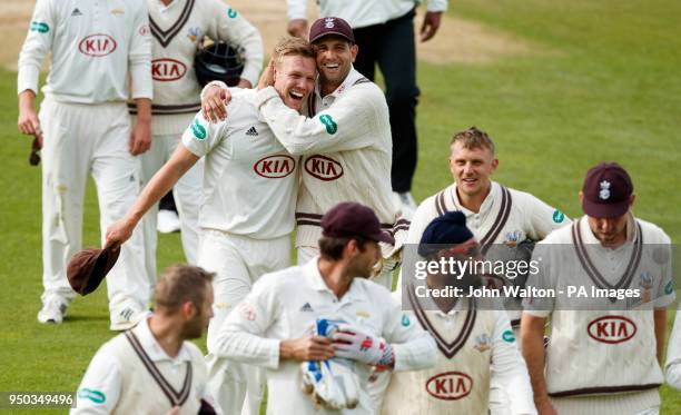 Surrey's Matthew Dunn, who took the final wicket of the match to win the game, celebrates as he walks off the pitch with teammate Jade Dernbach...