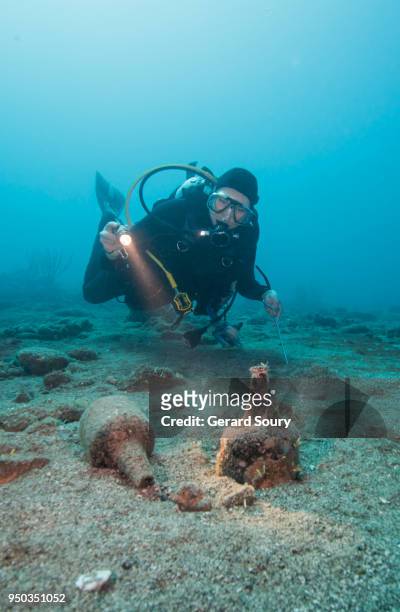 scuba diver examining old bottles from a sailboat shipwreck - archaeology stock pictures, royalty-free photos & images