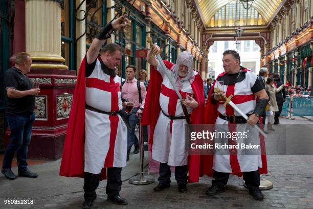 Three medieval knights spend lunchtime on St George's Day in Leadenhall Market in the capital's financial district , on 23rd April, City of London,...
