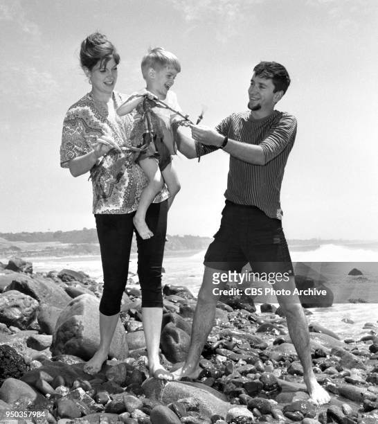 Bob Denver, star on the Many Loves of Dobie Gillis television comedy, relaxes with his wife Maggie and her 3 ½ year old son Kim, at Malibu Beach, CA....