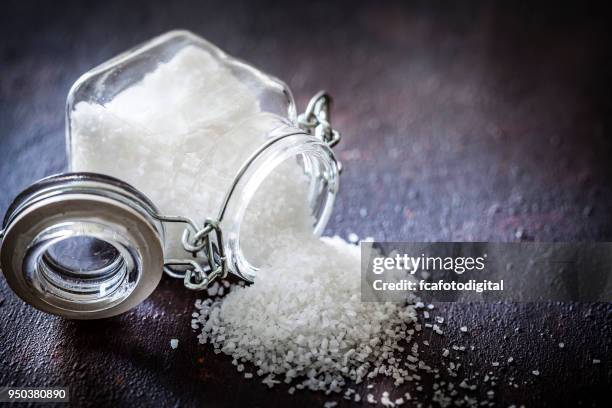 sal de mar de grano grueso en un recipiente de vidrio - sal mineral fotografías e imágenes de stock