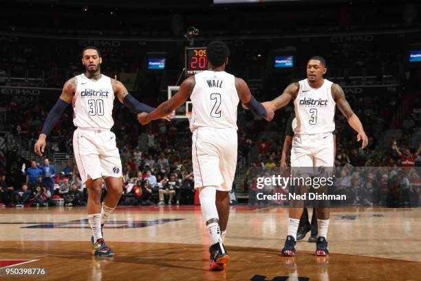 Mike Scott, John Wall, and Bradley Beal of the Washington Wizards react to a play against the Toronto Raptors in Game Four of Round One of the 2018...