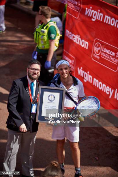 Runners dressed in fancy costumes receive a Guinness Record Certificate during the Virgin Money London Marathon in London, England on April 22, 2018.