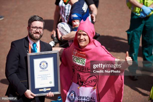 Runners dressed in fancy costumes receive a Guinness Record Certificate during the Virgin Money London Marathon in London, England on April 22, 2018.