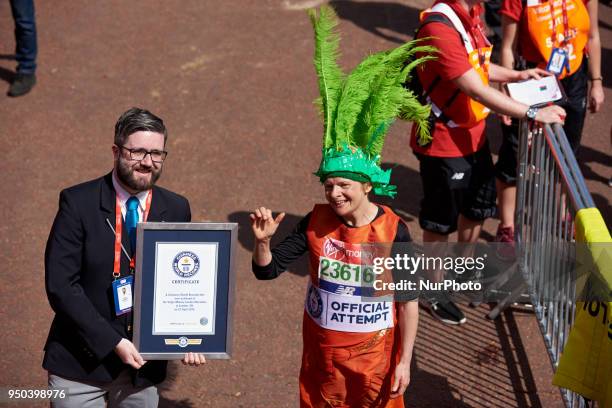 Runners dressed in fancy costumes receive a Guinness Record Certificate during the Virgin Money London Marathon in London, England on April 22, 2018.