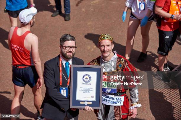 Runners dressed in fancy costumes receive a Guinness Record Certificate during the Virgin Money London Marathon in London, England on April 22, 2018.