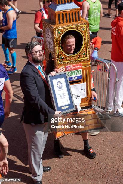 Runners dressed in fancy costumes receive a Guinness Record Certificate during the Virgin Money London Marathon in London, England on April 22, 2018.