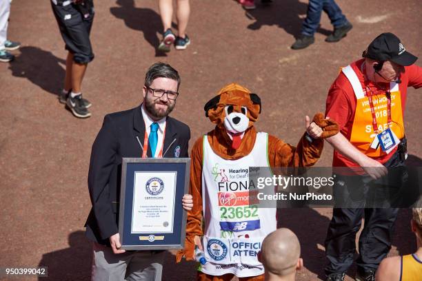 Runners dressed in fancy costumes receive a Guinness Record Certificate during the Virgin Money London Marathon in London, England on April 22, 2018.