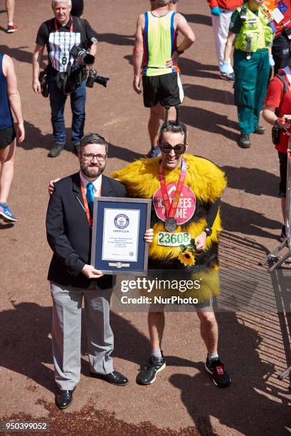 Runners dressed in fancy costumes receive a Guinness Record Certificate during the Virgin Money London Marathon in London, England on April 22, 2018.