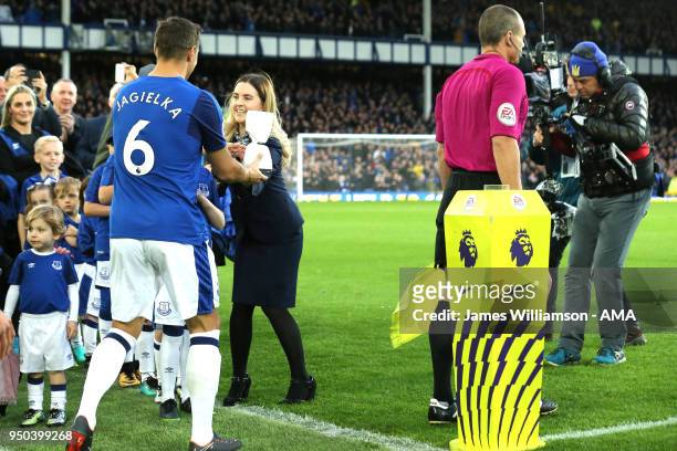Phil Jagielka of Everton is handed the Virtual mascot during the Premier League match between Everton and Newcastle United at Goodison Park on April...