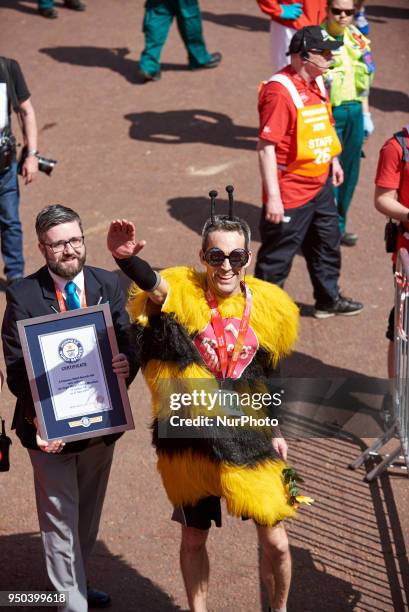 Runners dressed in fancy costumes receive a Guinness Record Certificate during the Virgin Money London Marathon in London, England on April 22, 2018.