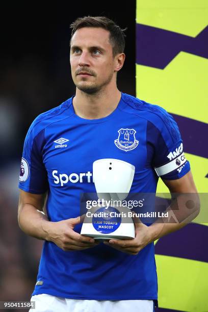 Phil Jagielka of Everton holds a robot cam to enable the Everton mascot to watch proceedings at home during the Premier League match between Everton...