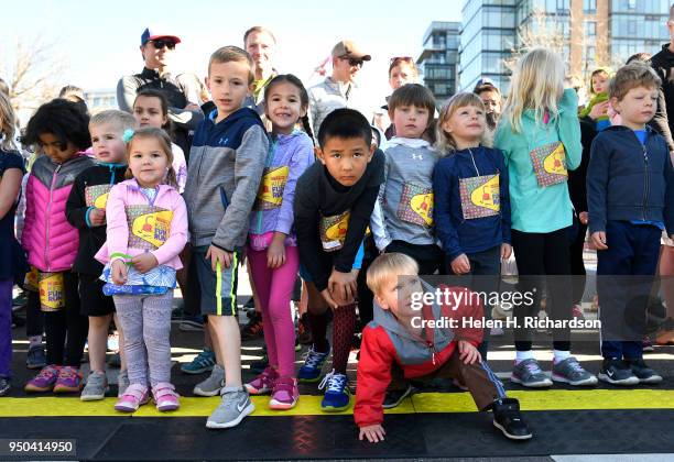 Stanley Tsai, middle 6th from right, and other young kids eye the clock as they get ready to start the kids 1/2 mile fun run from the starting line...