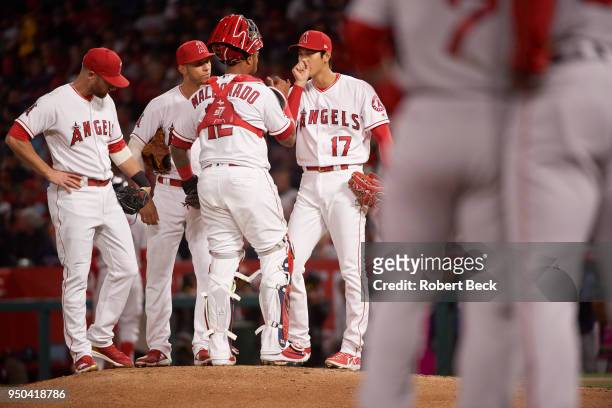 Los Angeles Angels Shohei Ohtani blowing on hand during mound visit with teammates during game vs Boston Red Sox at Angel Stadium. Anaheim, CA...
