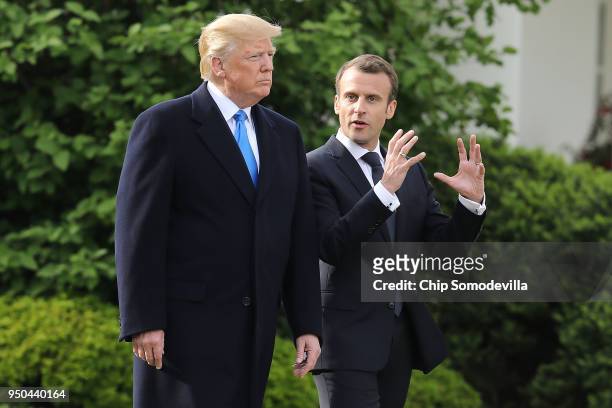 President Donald Trump and French President Emmanuel Macron walk out of the White House before participating in a tree-planting ceremony on the South...