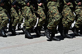 Army military soldiers marching in a parade outdoors.